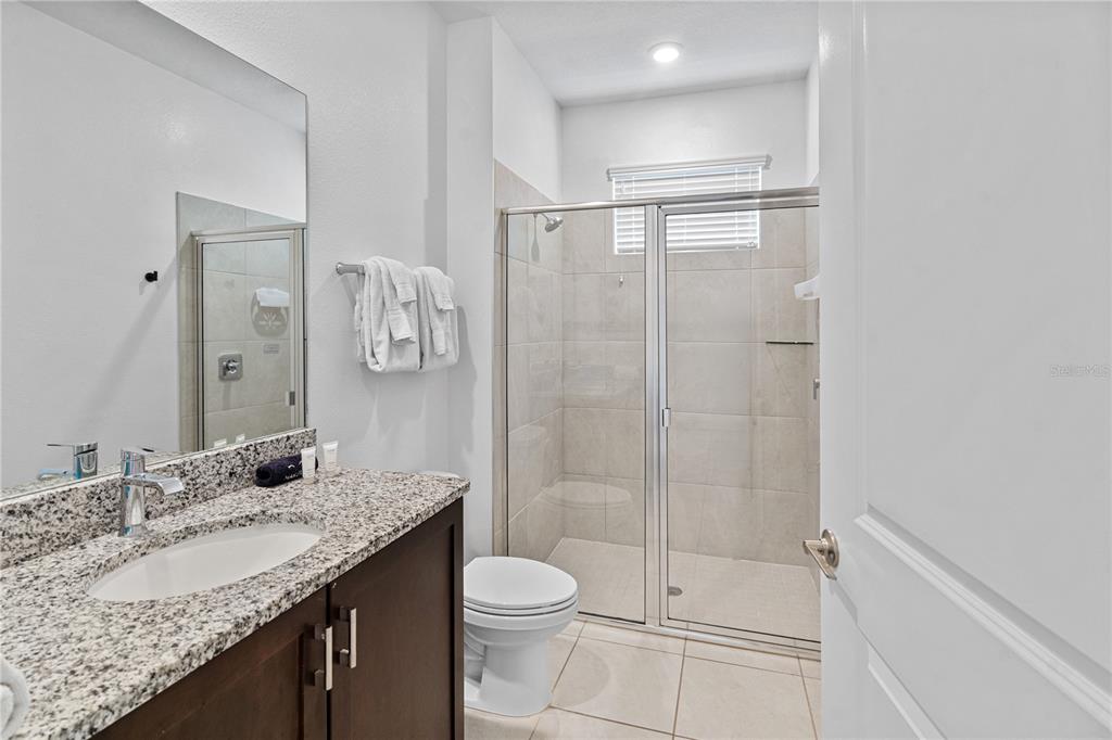7622 Excitement Drive Reunion, FL 34747 - Photo 9 of 46 a bathroom with a granite countertop sink a toilet and shower