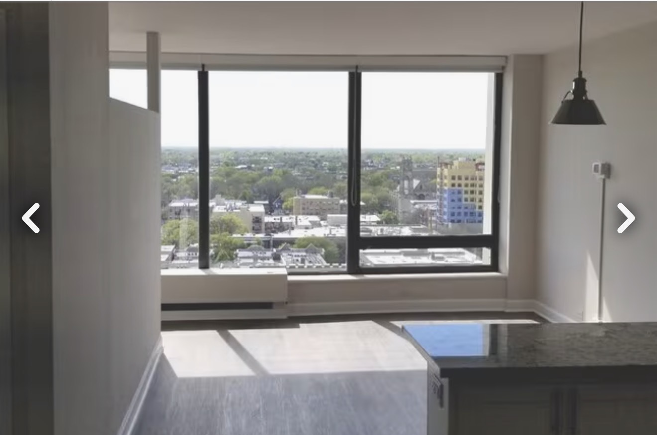 5445 North Sheridan Road, Unit 1805 Chicago, IL 60640 - Photo 3 of 12 a room with a large window and a bed