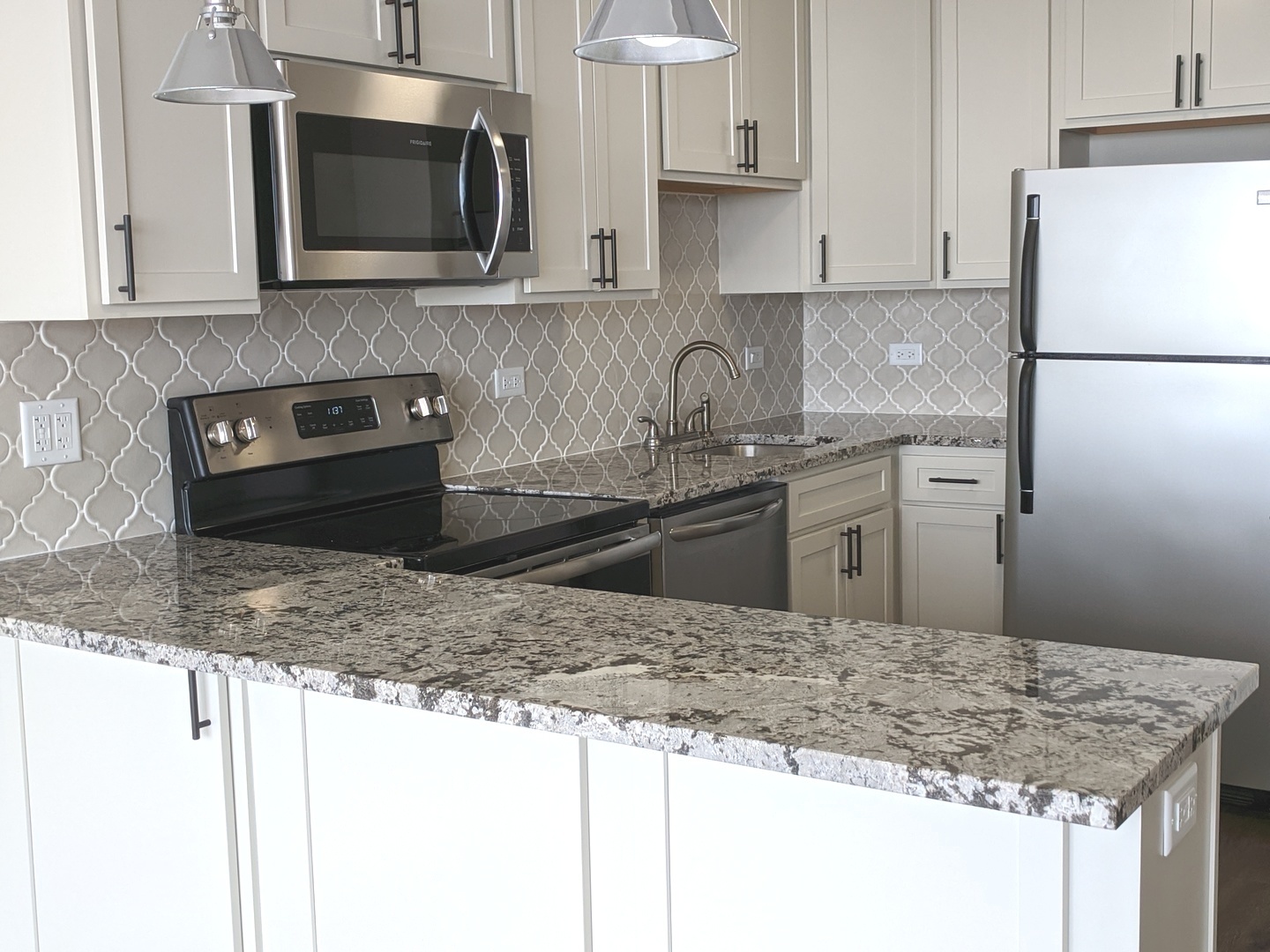 5445 North Sheridan Road, Unit 1805 Chicago, IL 60640 - Photo 5 of 12 a kitchen with stainless steel appliances granite countertop a sink stove and microwave