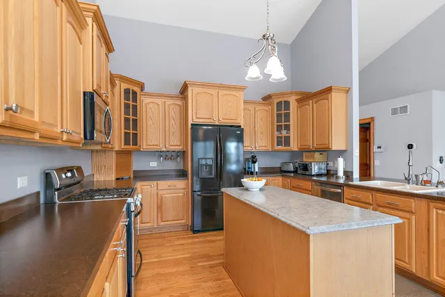 a kitchen with stainless steel appliances granite countertop a sink stove and refrigerator