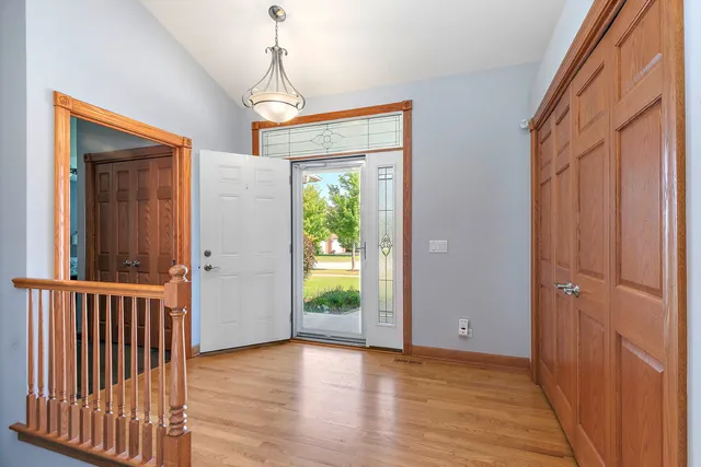 a view of a hallway with wooden floor and stairs