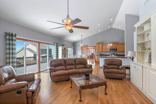 a living room with furniture ceiling fan and a large window