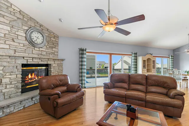 a living room with furniture a large window and a fireplace