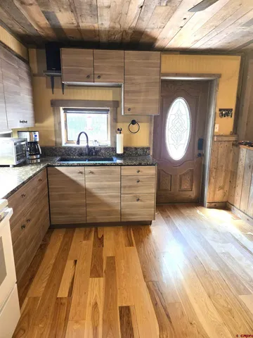 a kitchen with wooden floors and wooden cabinets