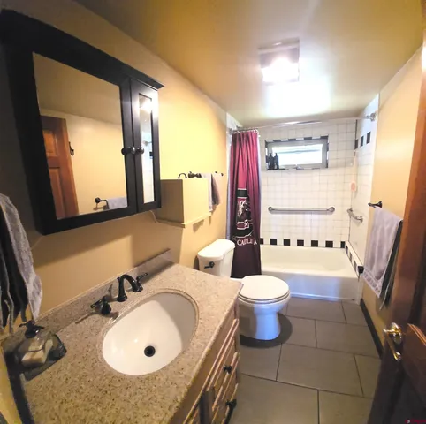 a bathroom with a sink and mirror with toilet