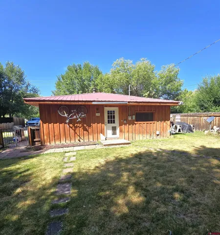 a view of a house with backyard and sitting area