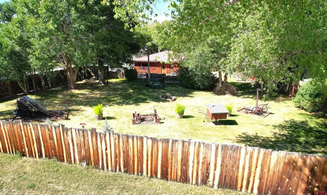 a view of a yard with wooden fence