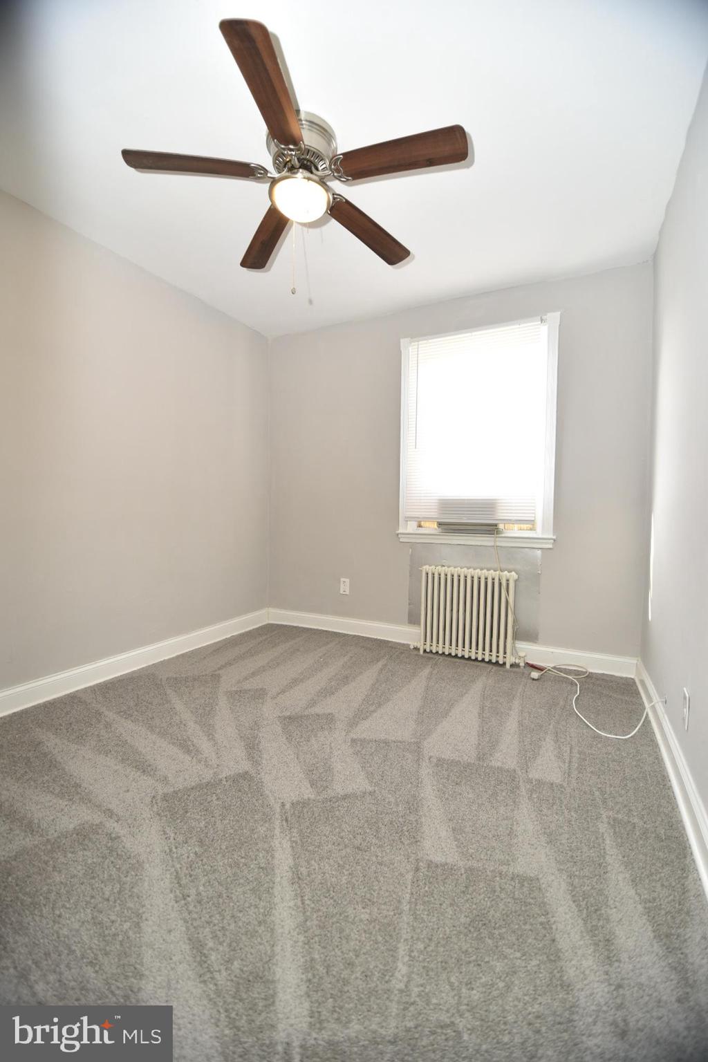 913 St Dunstans Road Baltimore, MD 21212 - Photo 8 of 28 an empty room with a ceiling fan and windows