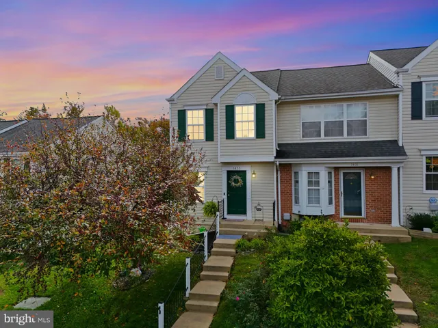 a front view of a house with a yard and trees