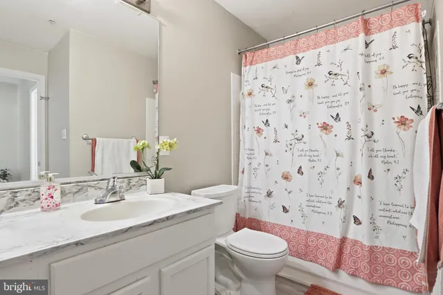 a bathroom with a granite countertop sink a toilet and a mirror