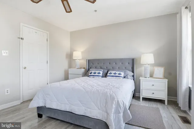 a bedroom with a bed and a lamp on dresser