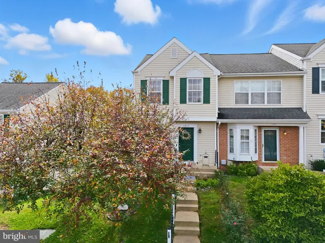 a front view of a house with a yard and trees