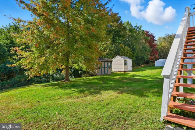 a view of a big house with a big yard and large trees