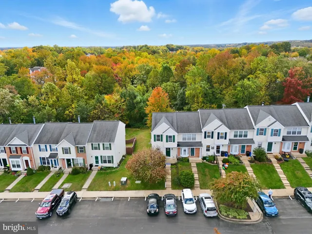 a aerial view of a house next to a big yard and large trees