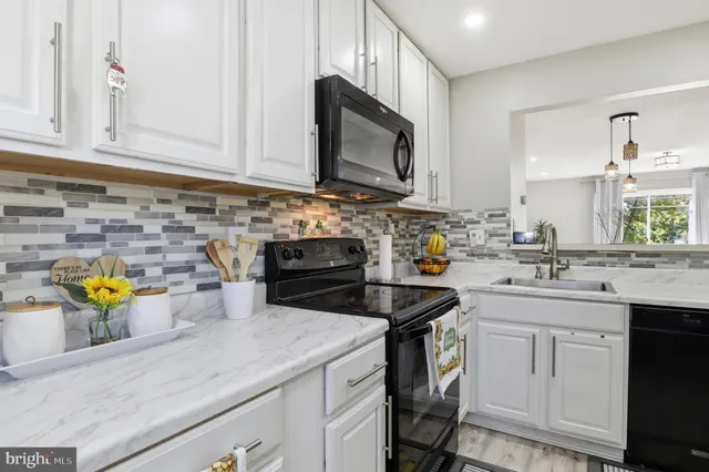 a kitchen with a sink a stove and cabinets