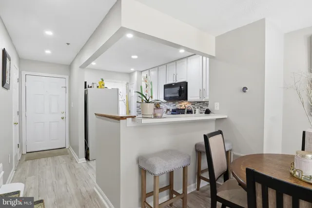 a kitchen with a table chairs refrigerator and microwave