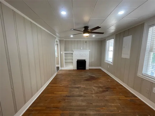 an empty room with windows and fireplace