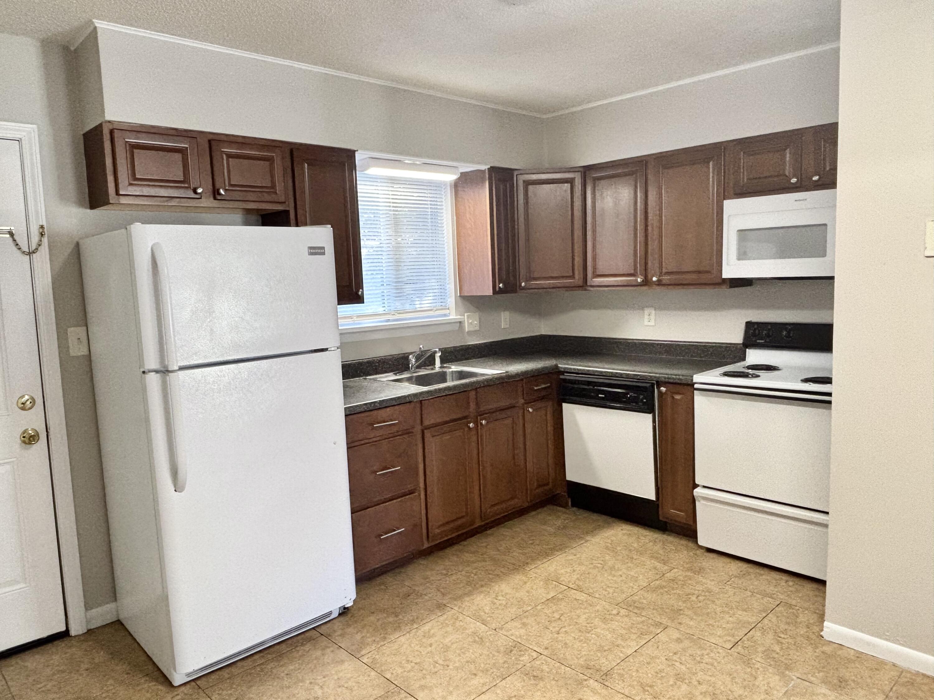 322 Pelham Road, Unit B Fort Walton Beach, FL 32547 - Photo 4 of 10 a kitchen with a refrigerator sink and cabinets
