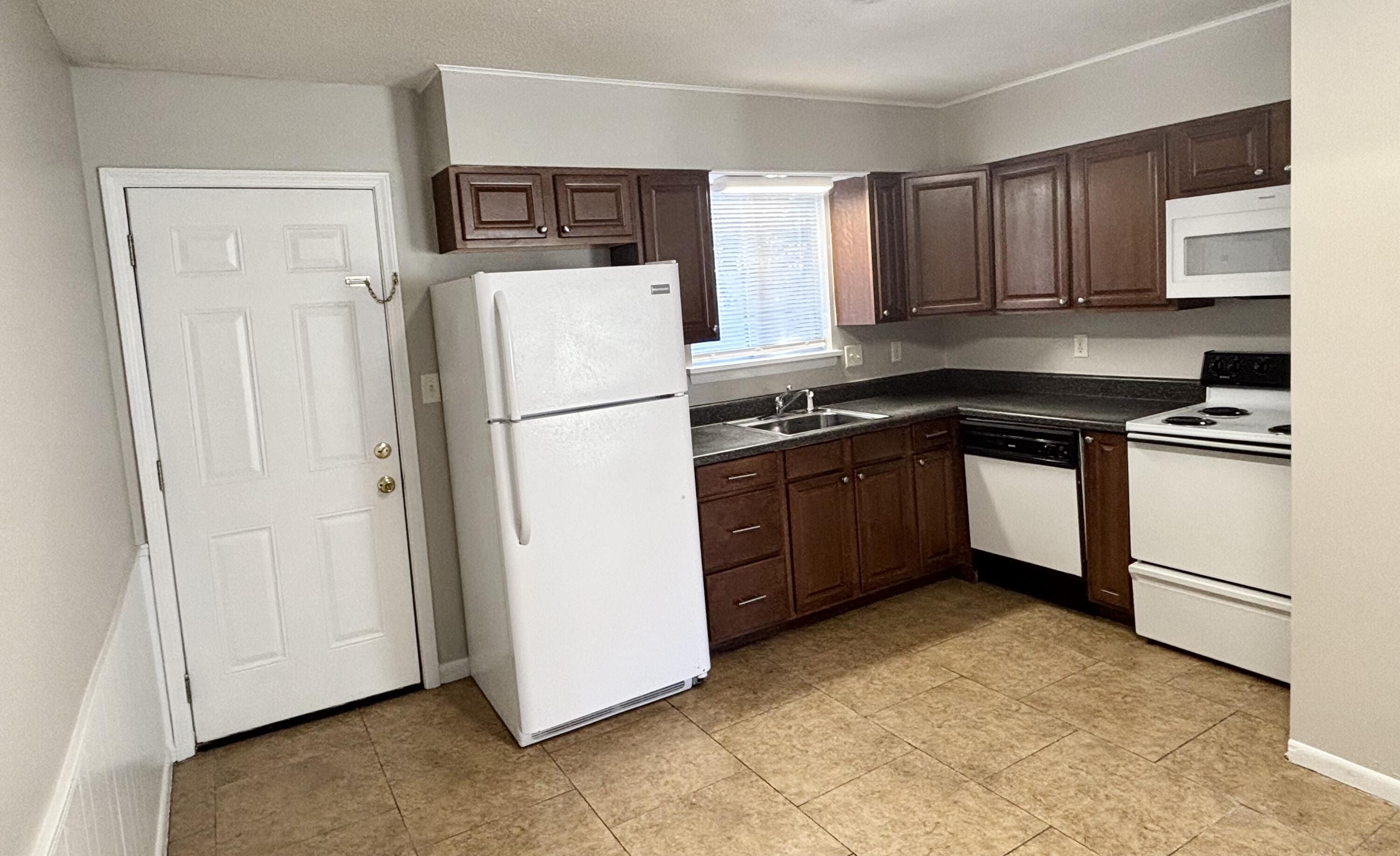 322 Pelham Road, Unit B Fort Walton Beach, FL 32547 - Photo 5 of 10 a kitchen with a refrigerator sink and cabinets