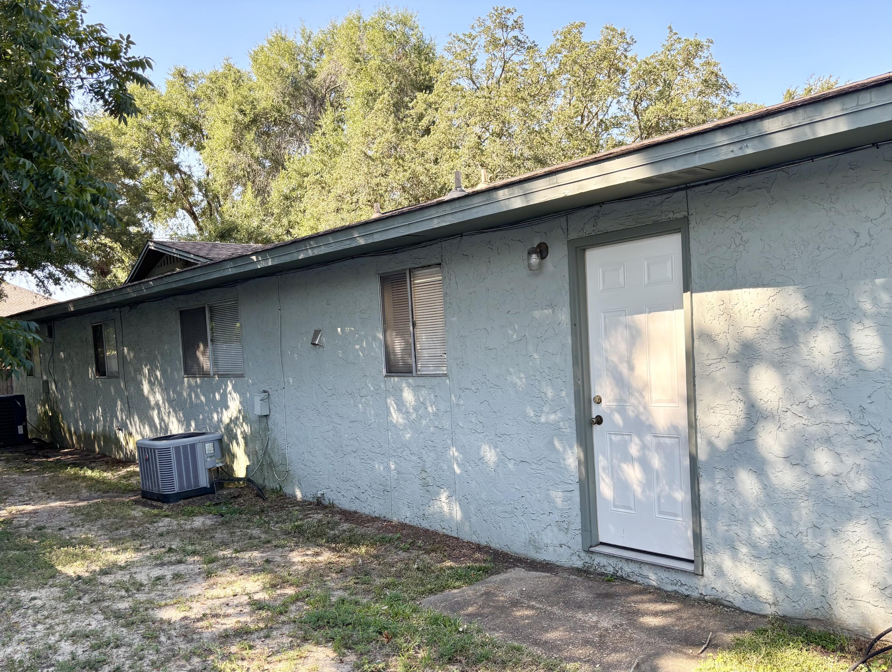 322 Pelham Road, Unit B Fort Walton Beach, FL 32547 - Photo 9 of 10 a backyard of a house with table and chairs