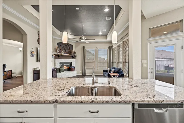 a kitchen with kitchen island granite countertop a sink and cabinets