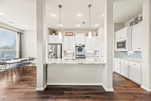 a large kitchen with kitchen island granite countertop a large counter top stainless steel appliances and cabinets