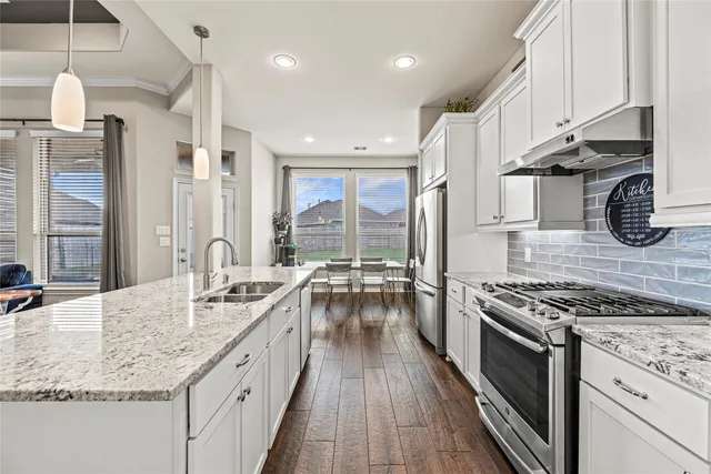 a kitchen with granite countertop a sink stove and cabinets