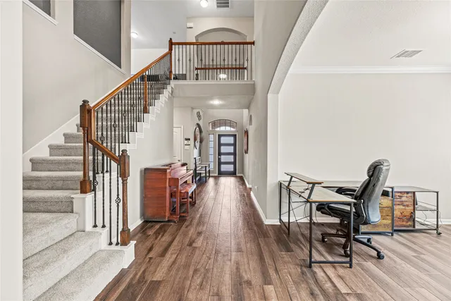 a view of a hallway with wooden floor and staircase