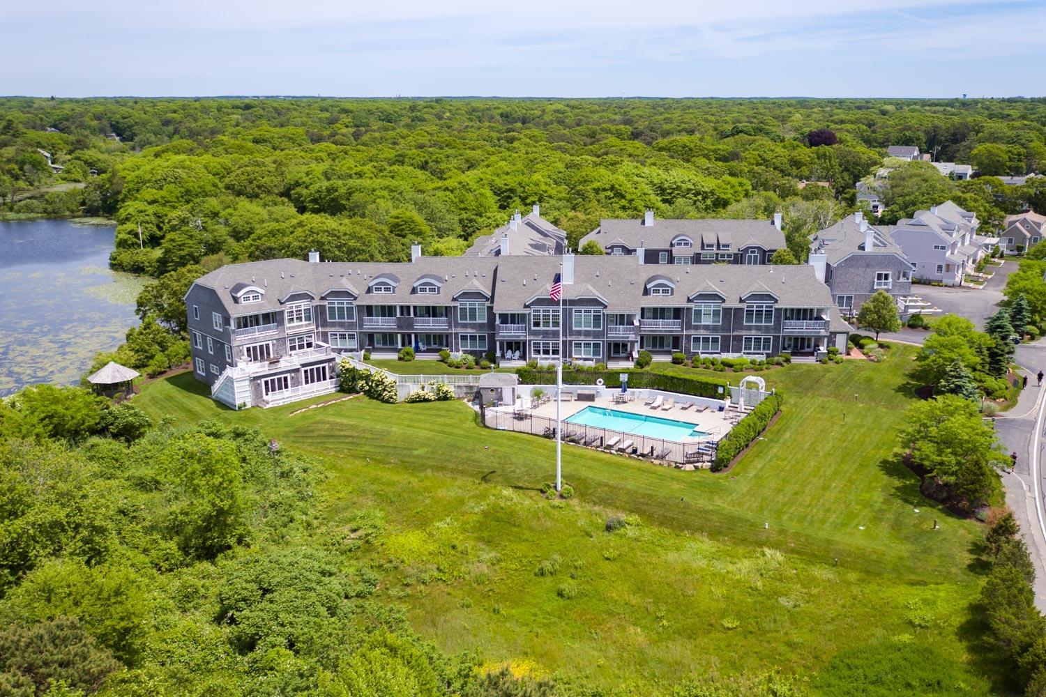 an aerial view of residential houses with outdoor space and swimming pool