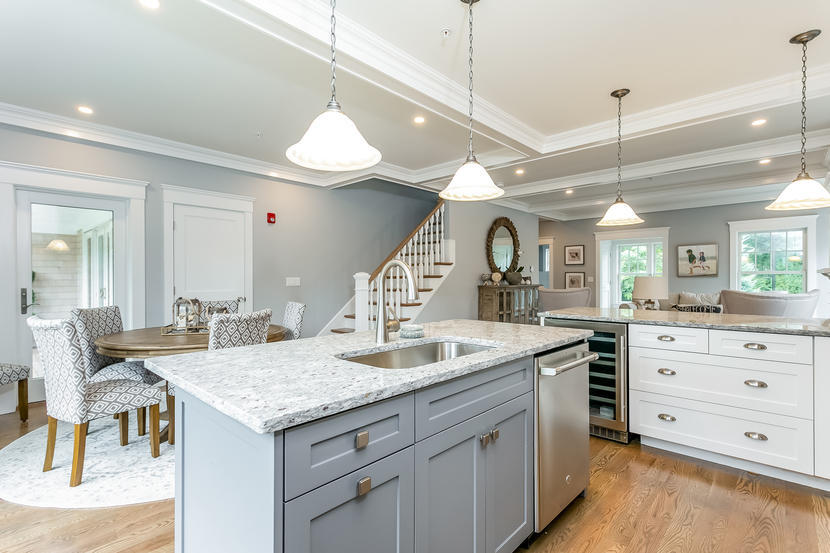 780 Craigville Beach Road, Unit F2 Centerville, MA 02632 - Photo 4 of 13 a large kitchen with kitchen island a stove a chandelier a dining table and chairs with wooden floor