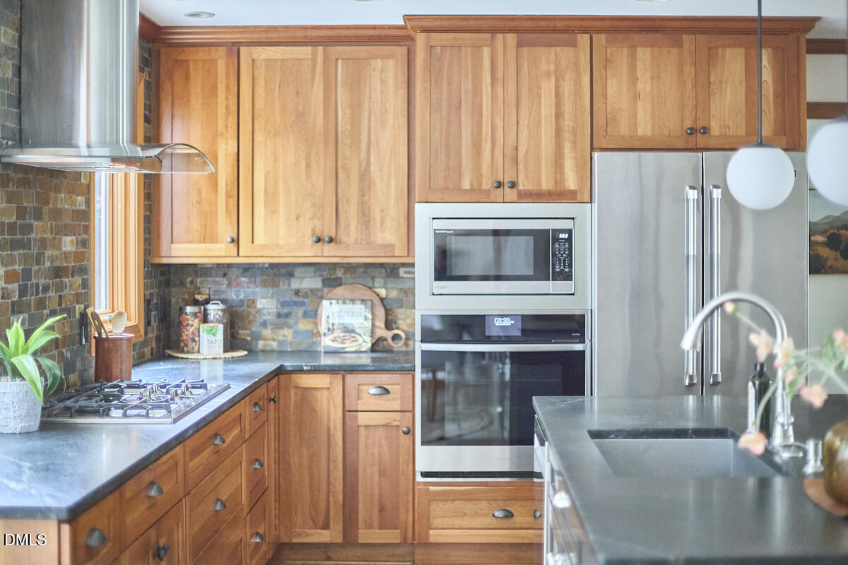 8109 Olde Hill Court Raleigh, NC 27615 - Photo 17 of 65 a kitchen with stainless steel appliances granite countertop a stove a sink and a microwave