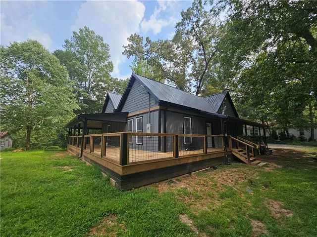 a view of a house with a wooden deck and a yard