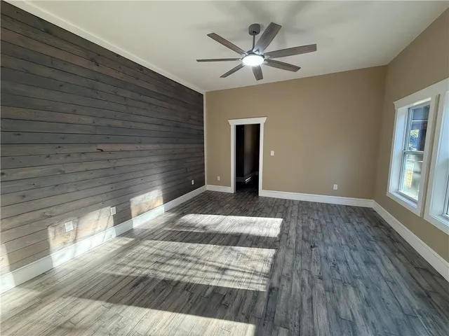 a view of a livingroom with wooden floor and a ceiling fan