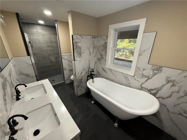 a bathroom with a sink a toilet and shower