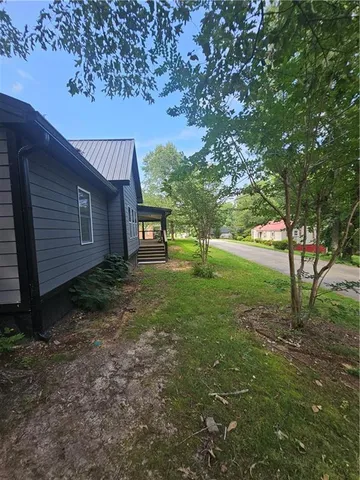 a view of a house with backyard and a tree