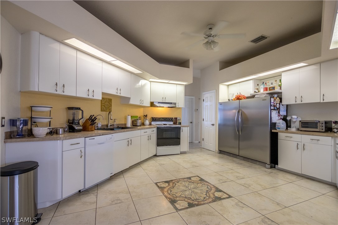 38830 Washington Loop Road Punta Gorda, FL 33982 - Photo 13 of 25 a kitchen with granite countertop a refrigerator and a stove top oven
