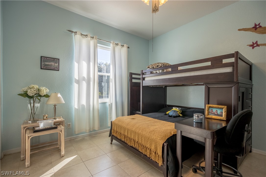 38830 Washington Loop Road Punta Gorda, FL 33982 - Photo 19 of 25 a bedroom with a bed and a chandelier