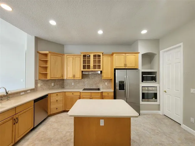 a large kitchen with stainless steel appliances kitchen island a large counter top and a sink
