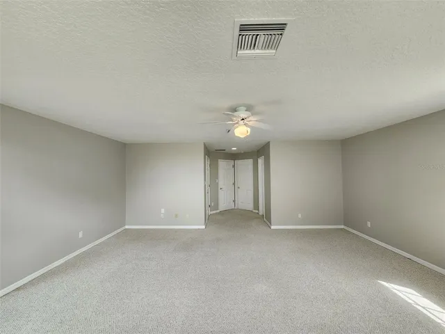 an empty room with a ceiling fan and window