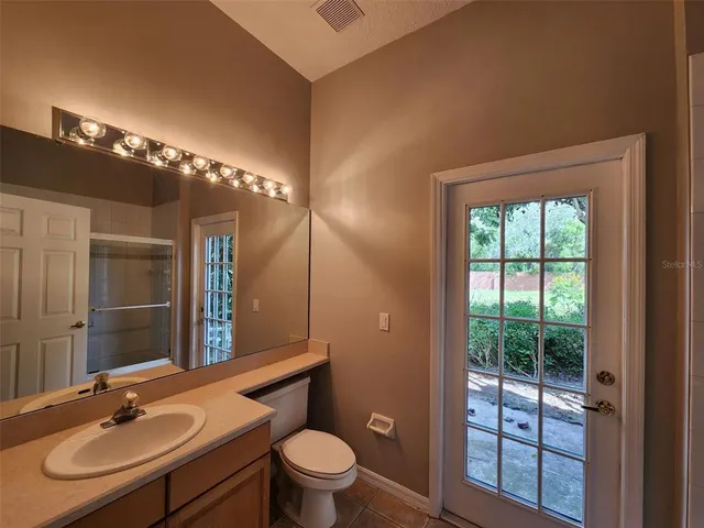 a bathroom with a sink a toilet a mirror and window