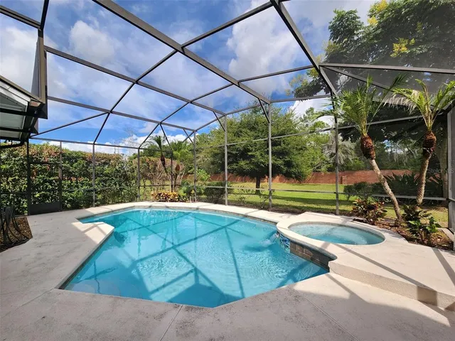 a view of a backyard with swimming pool and sitting area