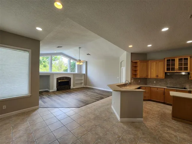 a kitchen with granite countertop a stove top oven sink and cabinets