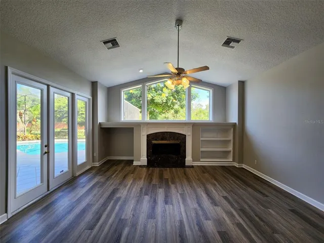 a living room with a fireplace and wooden floor