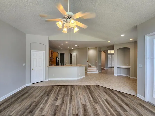 a view of a room with wooden floor and ceiling fan