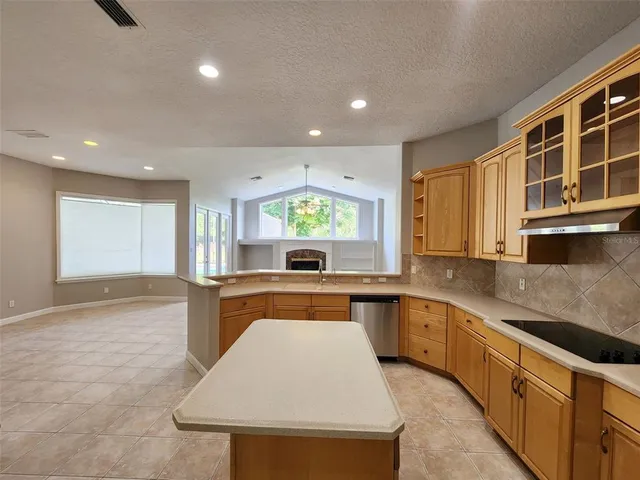 a large kitchen with kitchen island a sink stainless steel appliances and cabinets