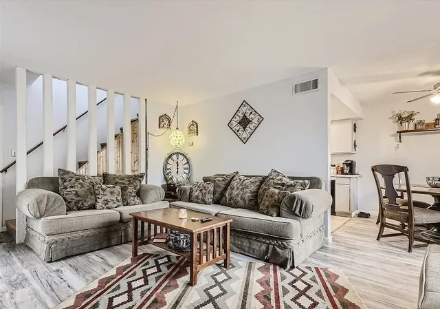 a living room with furniture and wooden floor
