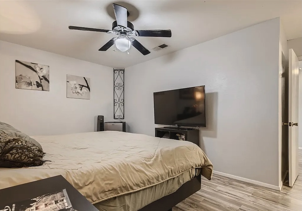 9026 Sawtooth Lane, Unit A Austin, TX 78729 - Photo 6 of 10 a bedroom with a bed and a flat screen tv