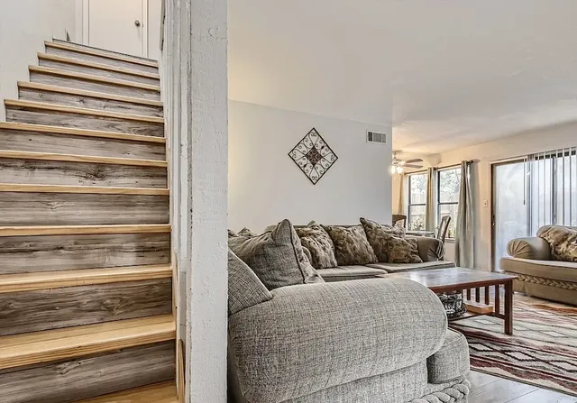 a living room with furniture and a floor to ceiling window