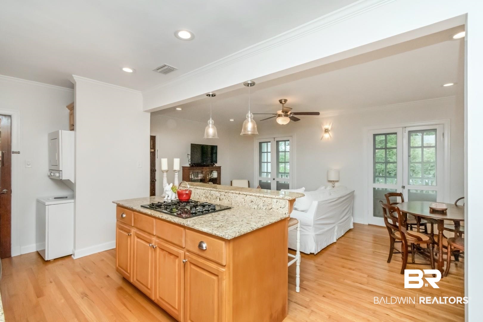 214 Upham Street, Unit 3D Mobile, AL 36607 - Photo 34 of 34 Kitchen featuring a kitchen island, open floor plan, light stone countertops, crown molding, and a kitchen bar