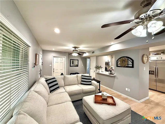 a living room with furniture and a wooden floor